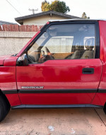 1989 Suzuki Sidekick JLX 4x4 parked with visible wear, ready for restoration and new paint job.