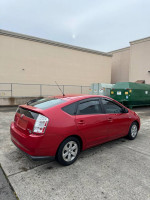 2007 Toyota Prius in red, showing clean design and low mileage, ideal for eco-friendly driving.