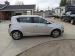 2012 Chevrolet Sonic LT in silver parked on a driveway, showcasing low mileage and clean exterior.