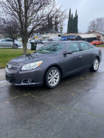 2014 Chevrolet Malibu LTZ in gray parked on a wet street, showcasing its sleek design and clean exterior.