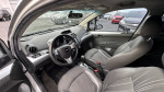 Interior view of a 2013 Chevrolet Spark featuring leather and cloth seats, automatic controls, and a touchscreen radio.