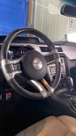 Interior view of a 2014 Ford Mustang V6 with leather upholstery and modern dashboard controls.