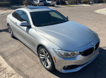 2015 silver BMW 435i with black leather interior parked on the street, showcasing sporty design and M performance features.
