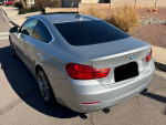 2015 silver BMW 435i with black leather interior parked on the street.