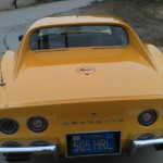 Rear view of a yellow 1973 Chevrolet Corvette Stingray with removable T-top, showcasing its sleek design.