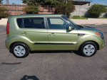 Side view of a 2013 Kia Soul in green with low mileage, in excellent condition and ready for sale.