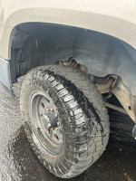 Close-up of a rugged tire on a 2007 GMC Sierra 2500HD showcasing its tread and wheel design.