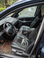 Interior view of a 2004 Volvo XC90 with worn leather seats and dashboard.