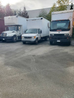 2000 GMC T7500 truck with 26ft box and power tailgate parked alongside other vehicles.