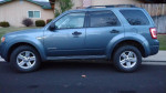 2012 Ford Escape Hybrid in blue color, showcasing its clean exterior and AWD features parked on the street