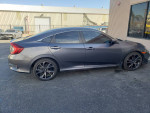 2019 Honda Civic Sport FWD in grey, side view, showcasing sleek design and sporty wheels.