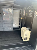 Interior of a 2007 Ford E-250 Cargo Van with storage shelves and inverter, ideal for work use.