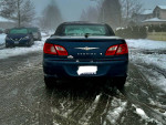 Rear view of a 2008 Chrysler Sebring LX in excellent condition parked on a snowy street.