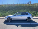 2000 Honda Civic hatchback in silver parked on the street with modern wheels and a clean exterior.
