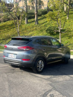2016 Hyundai Tucson SUV parked in a residential area, showing its clean title and minor exterior scratches.